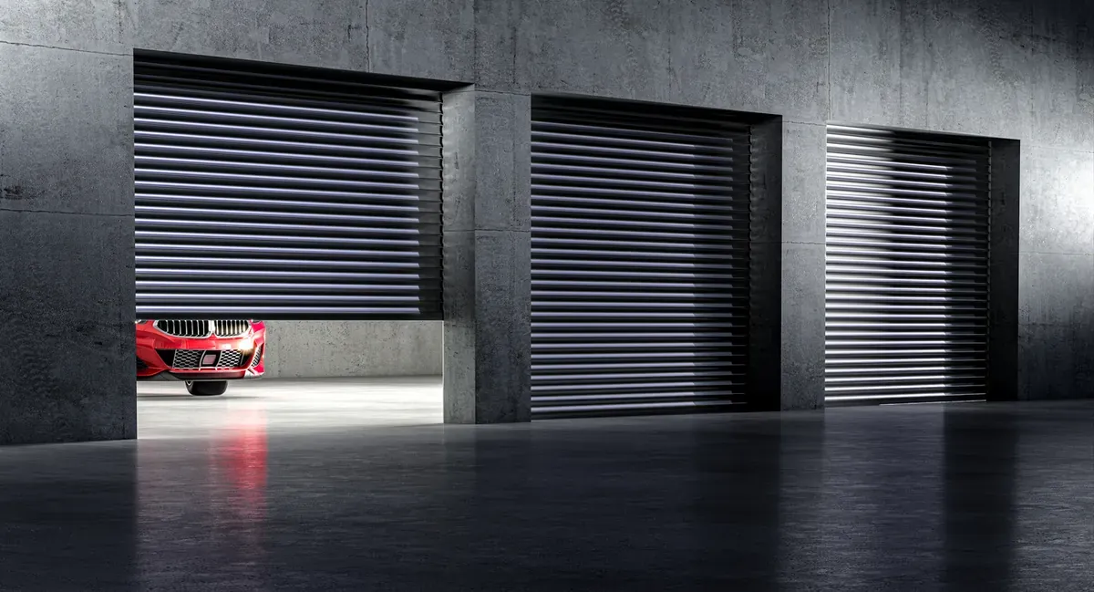 A red car stored in the bay of a large modern vehcile storage facility.