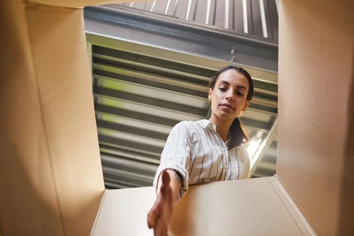 A young woman reaching into a box while loading a storage unit.